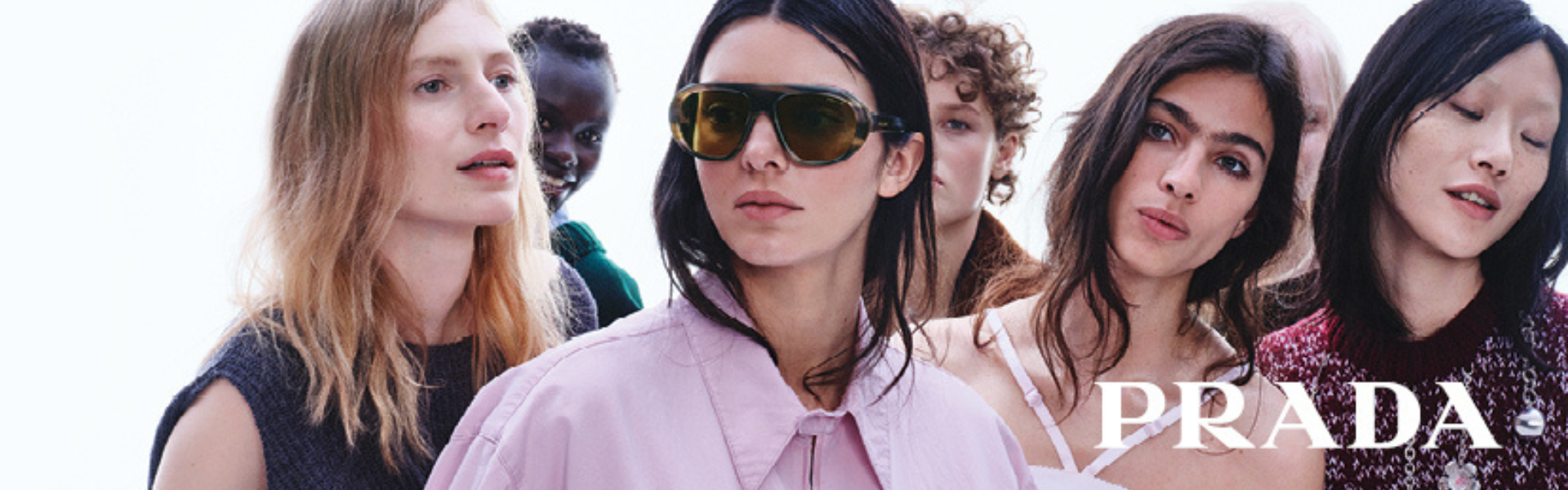 Prada sunglasses collection for women featuring multiple models worn by individuals in a studio-style campaign banner